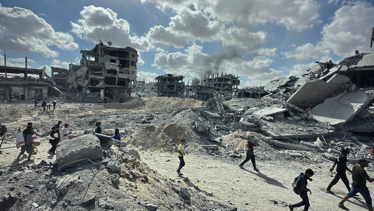 Palestinians walk among the rubble of destroyed buildings in Khan Yunis, in the southern Gaza Strip, on Oct. 10.
