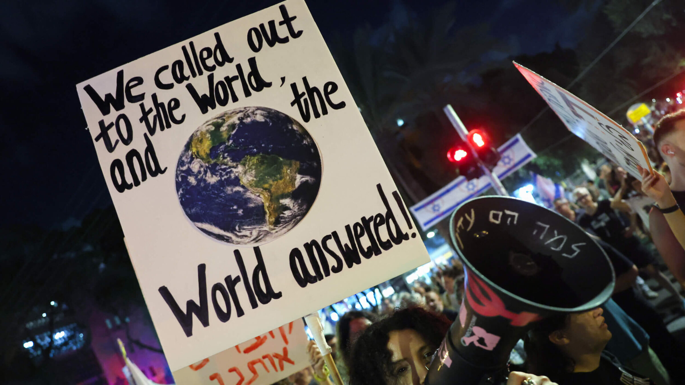Demonstrators lift placards during an anti-government protest calling for a ceasefire and the return of Israelis held hostage in Gaza, in front of the Likud party building in Tel Aviv on Sept. 30.