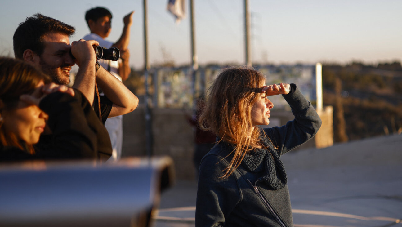 People standing at a viewpoint Sderot in southern Israel look at the damage in the Gaza Strip on Oct. 14.