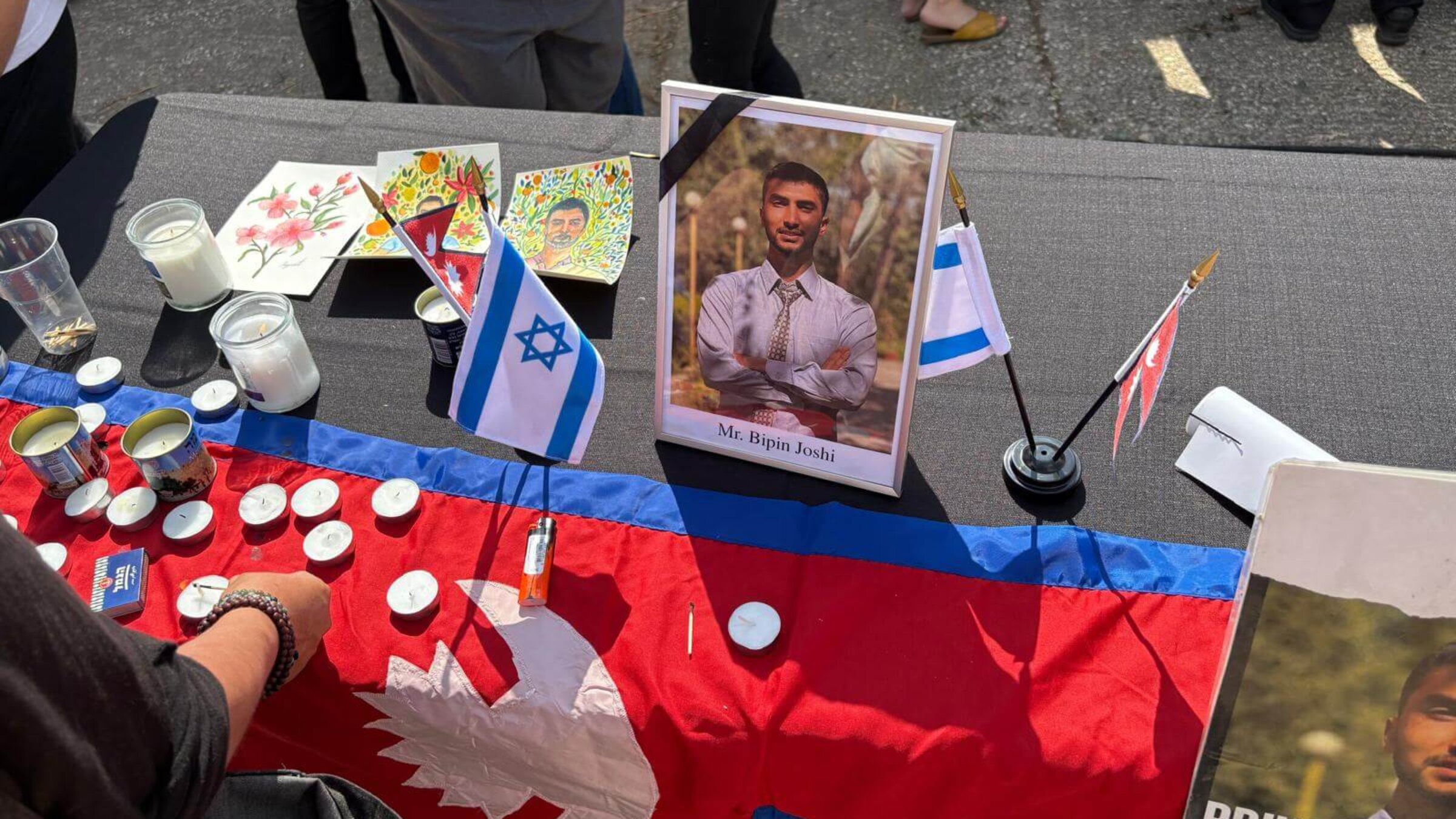 אַ פּאָרטרעט פֿון ביפּין דזשאָשי בעת דער הזכּרה־צערעמאָניע לעבן דעם פֿליפֿעלד אין בן־גוריון פֿליפֿעלד, איידער מע האָט געבראַכט זײַן אָרון קיין נעפּאַל, דעם 19טן אָקטאָבער