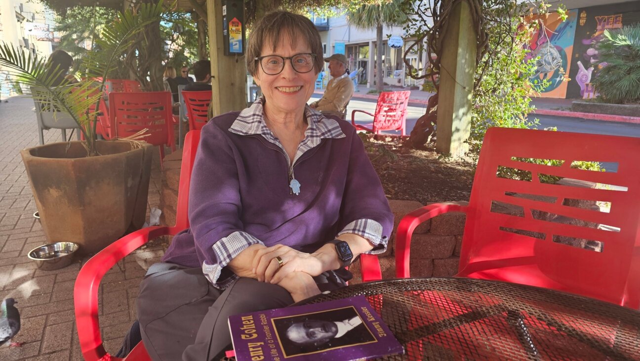Shelley Nussenblatt Kessler, a descendant of Jewish immigrants who came to America as part of the Galveston Movement in the early 20th century, sits in Galveston, Texas, with a biography of the city’s famous rabbi, Henry Cohen. 