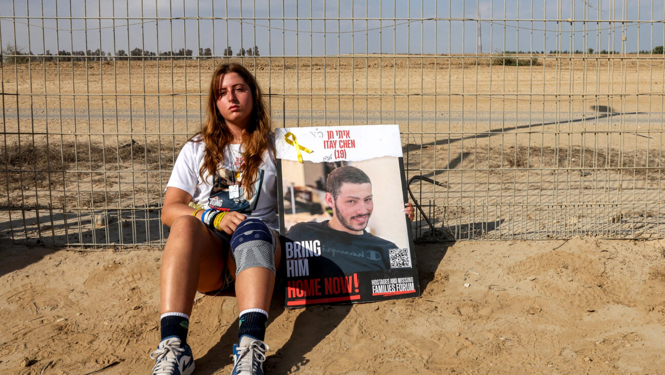 A woman sits with a sign identifying Itay Chen, an Israeli soldier missing since the October 7 attacks by Palestinian militants and confirmed dead by the Israeli army, during a demonstration by the families of the hostages calling for their release, near Kibbutz Nirim in southern Israel by the border with Gaza on August 29, 2024 amid the ongoing conflict in the Palestinian territory between Israel and Hamas. (Photo by JACK GUEZ / AFP) (Photo by JACK GUEZ/AFP via Getty Images)
