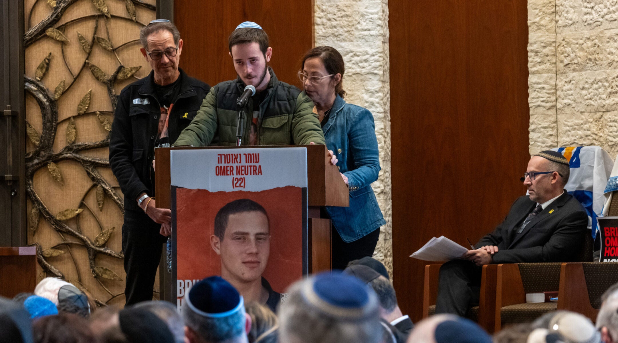 Ronen and Orna Neutra, with their son Daniel, speak at the Midway Jewish Center on Long Island during a memorial service for their son, Omer Neutra, an Israeli American soldier killed on Oct. 7, in Syosset, New York, Dec. 3, 2024.