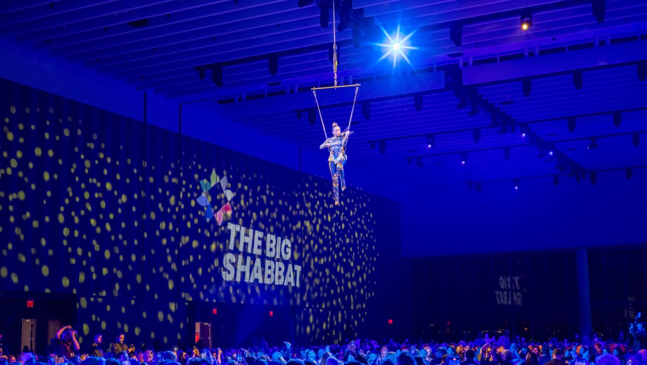 A violinist suspended from the ceiling plays songs from "Fiddler on the Roof" at "The Big Shabbat."
