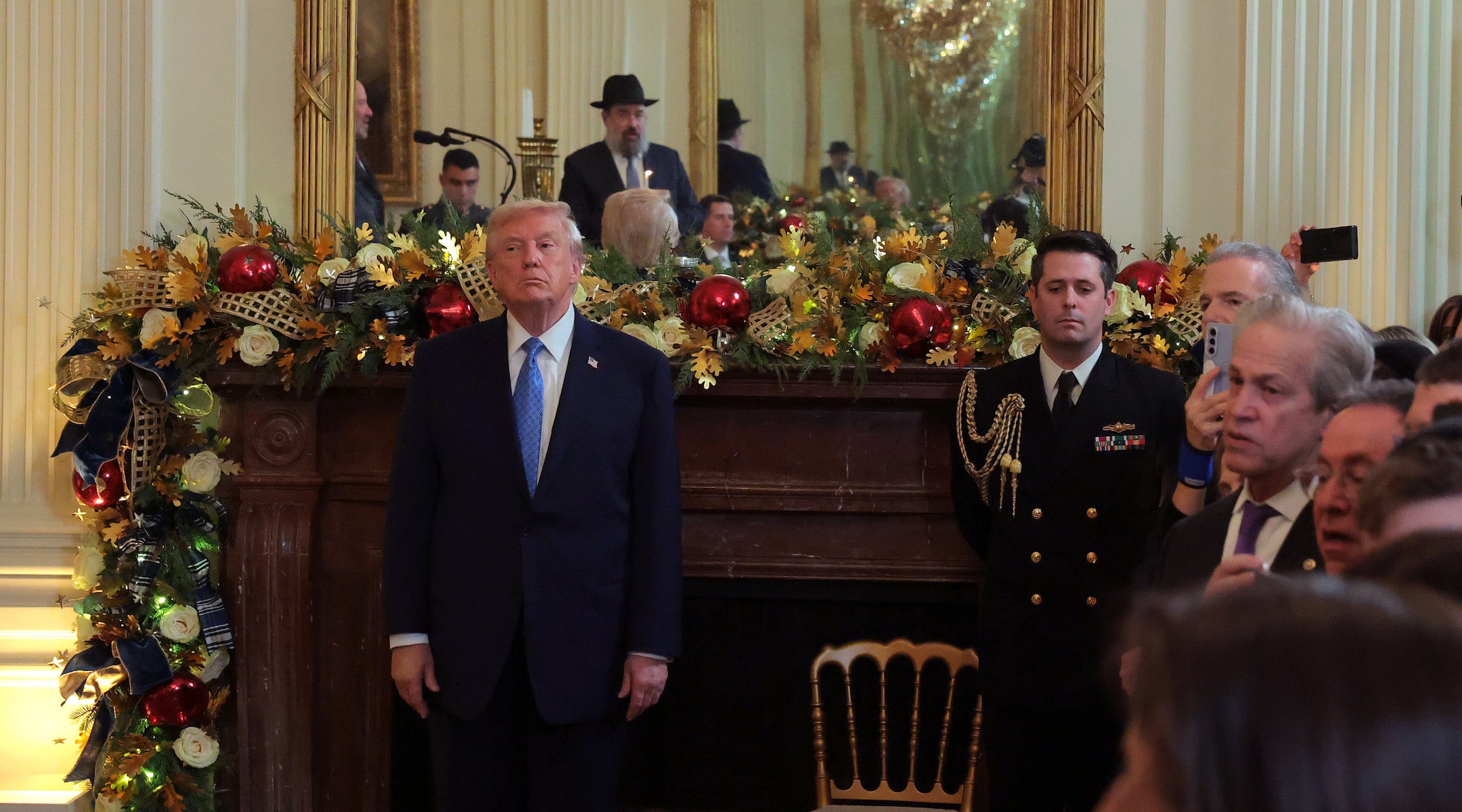President Donald Trump (L) looks on during a Hanukkah Reception in the East Room of the White House on December 16, 2025 in Washington, DC. Trump hosted attendees to celebrate the holiday and the lighting of the menorah on the third night of Hanukkah.