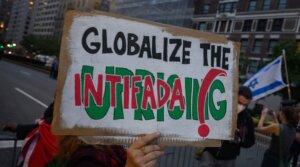 A pro- Palestinian protester holds a “globalize the intifada” sign near during an anti-Israel protest in New York City, Sept. 25, 2025.