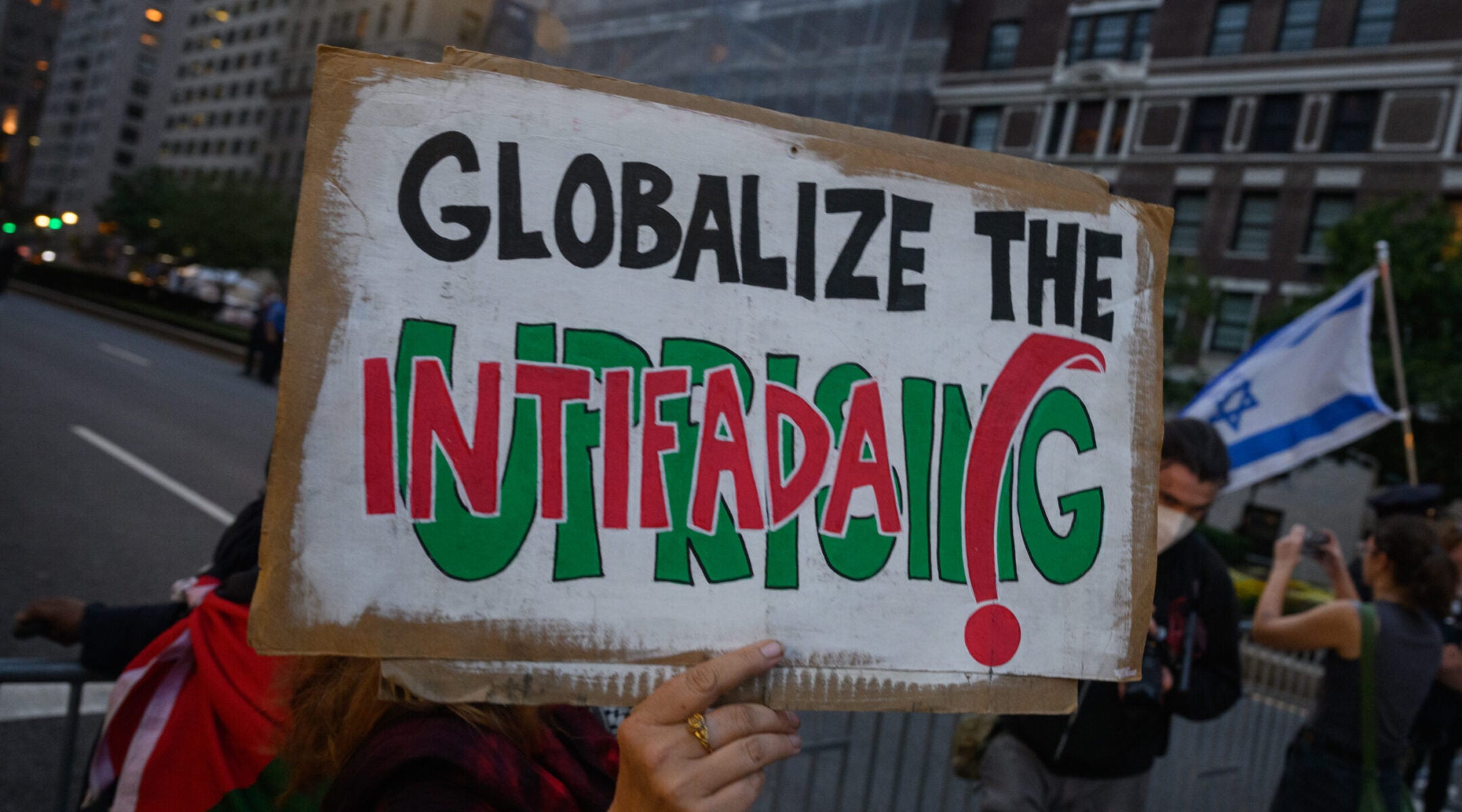 A pro- Palestinian protester holds a “globalize the intifada” sign near during an anti-Israel protest in New York City, Sept. 25, 2025.