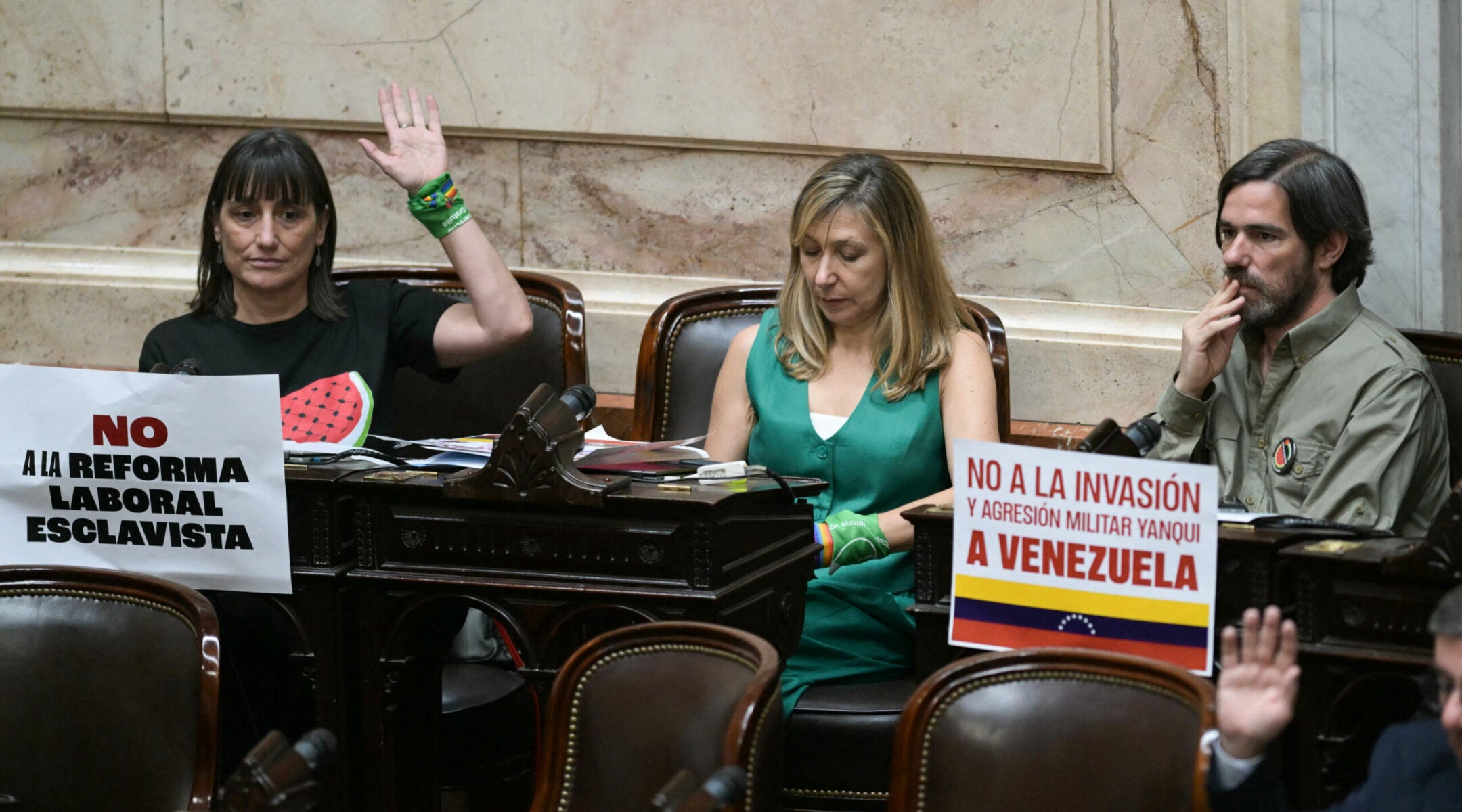 Argentina's Frente de Izquierda deputies Romina del Pla, Miryam Bregman, and Nicolas Del Cano (from left) sit at their desks during the oath ceremony at the Chamber of Deputies of the Argentine Congress in Buenos Aires on Dec. 3, 2025.
