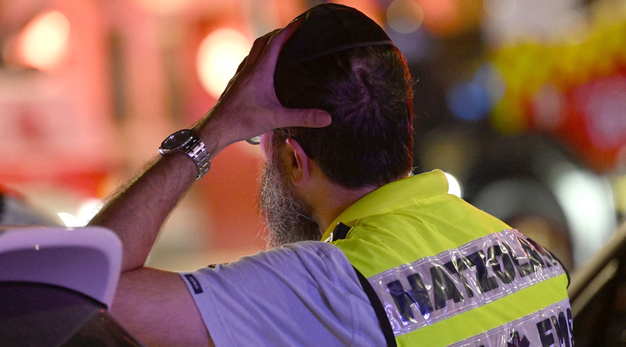 A Jewish first responder reacts as he stands at the site of the shooting incident at Bondi Beach in Sydney on Dec. 14.