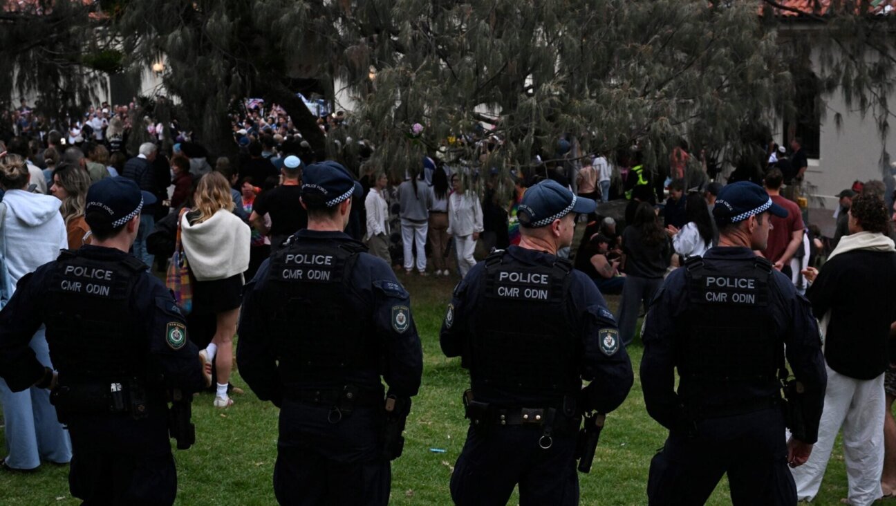 Police stand guard as mourners gather at a tribute at the Bondi Pavilion in memory of the victims of a shooting at Bondi Beach, in Sydney on Dec. 16.