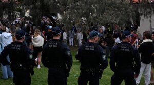 Police stand guard as mourners gather at a tribute at the Bondi Pavilion in memory of the victims of a shooting at Bondi Beach, in Sydney on Dec. 16.