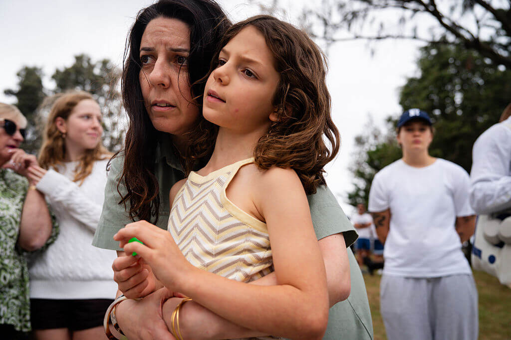 Nathalie Samia and her daughter, Yasmin Patterson, 8, grieve for Jewish friends in the community as people gather to mourn in the wake of a mass shooting at Bondi Beach on December 15, 2025 in Sydney, Australia.