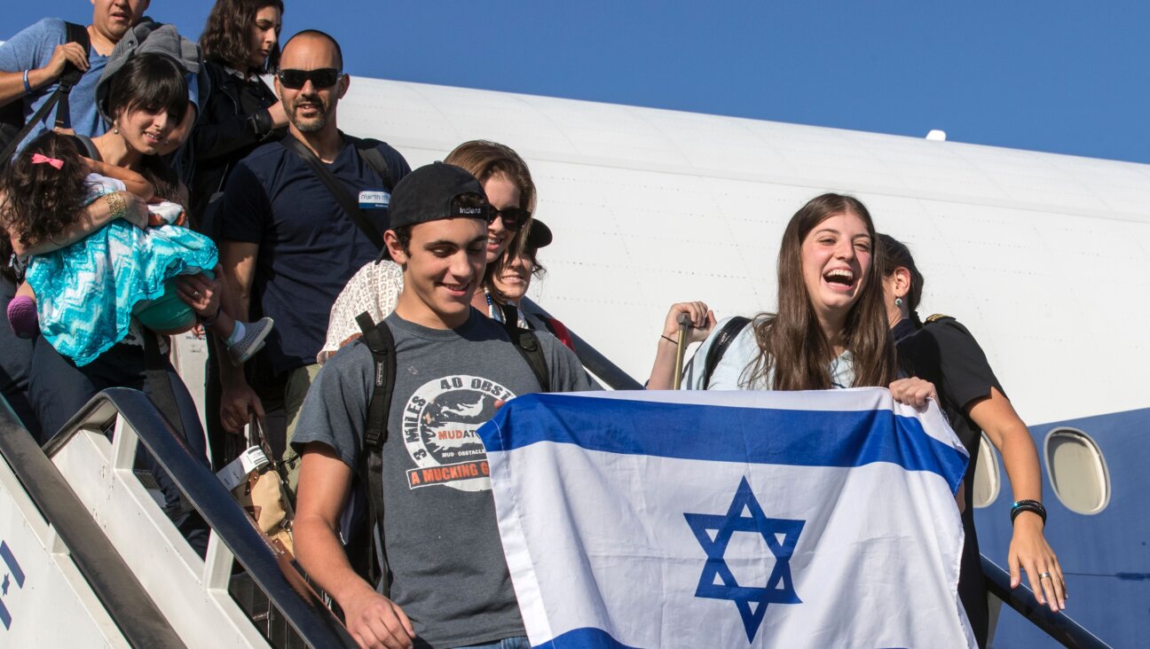 Newly arrived Jewish immigrants coming from North America hold an Israeli flag as they disembark a plane following their arrival at the Ben Gurion International Airport near Tel Aviv in 2016.