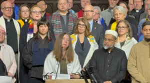 Rabbi Tamar Magill-Grimm, of the Conservative Beth Shalom Congregation in Mendota Heights, Minnesota, speaks out with other faith leaders against Immigrations and Customs Enforcement operations in the Twin Cities at a press conference at a Lutheran church in St. Paul, Jan. 20, 2026. Local cantors Tamar Havilio and Rachel Stock Spilker are behind Magill-Grimm to the right.