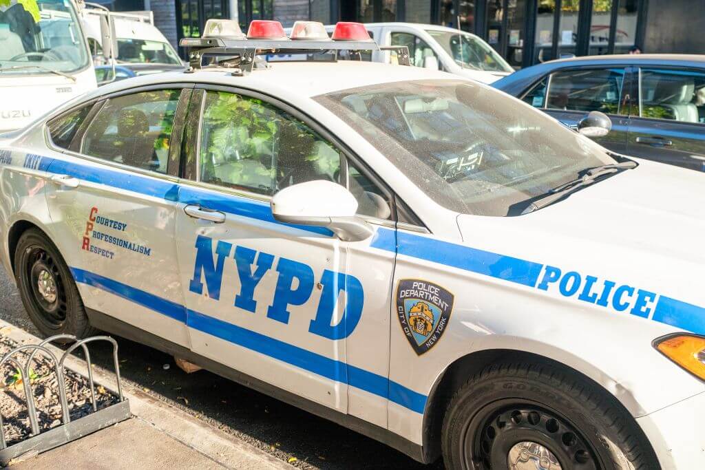 An NYPD car parked on a city street.