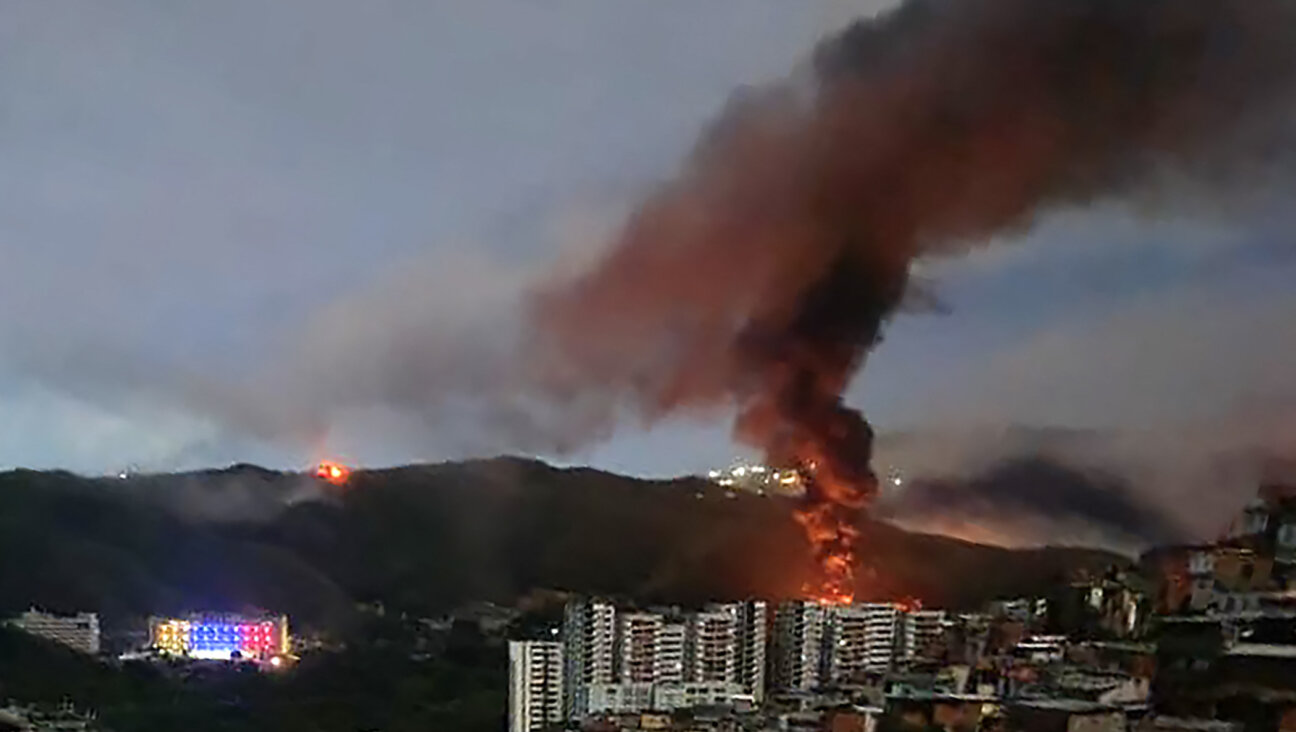 Fire at Fuerte Tiuna, Venezuela's largest military complex, is seen from a distance after a series of explosions in Caracas on Jan. 3, 2026. 