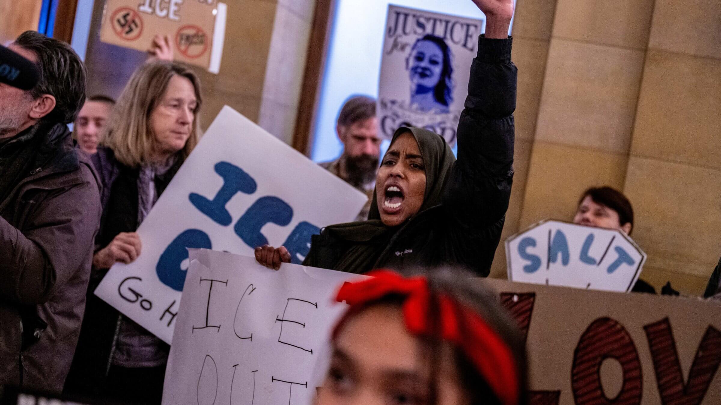 Protesters shout slogans against ICE officers outside of the office of Minnesota Governor Tim Walz.