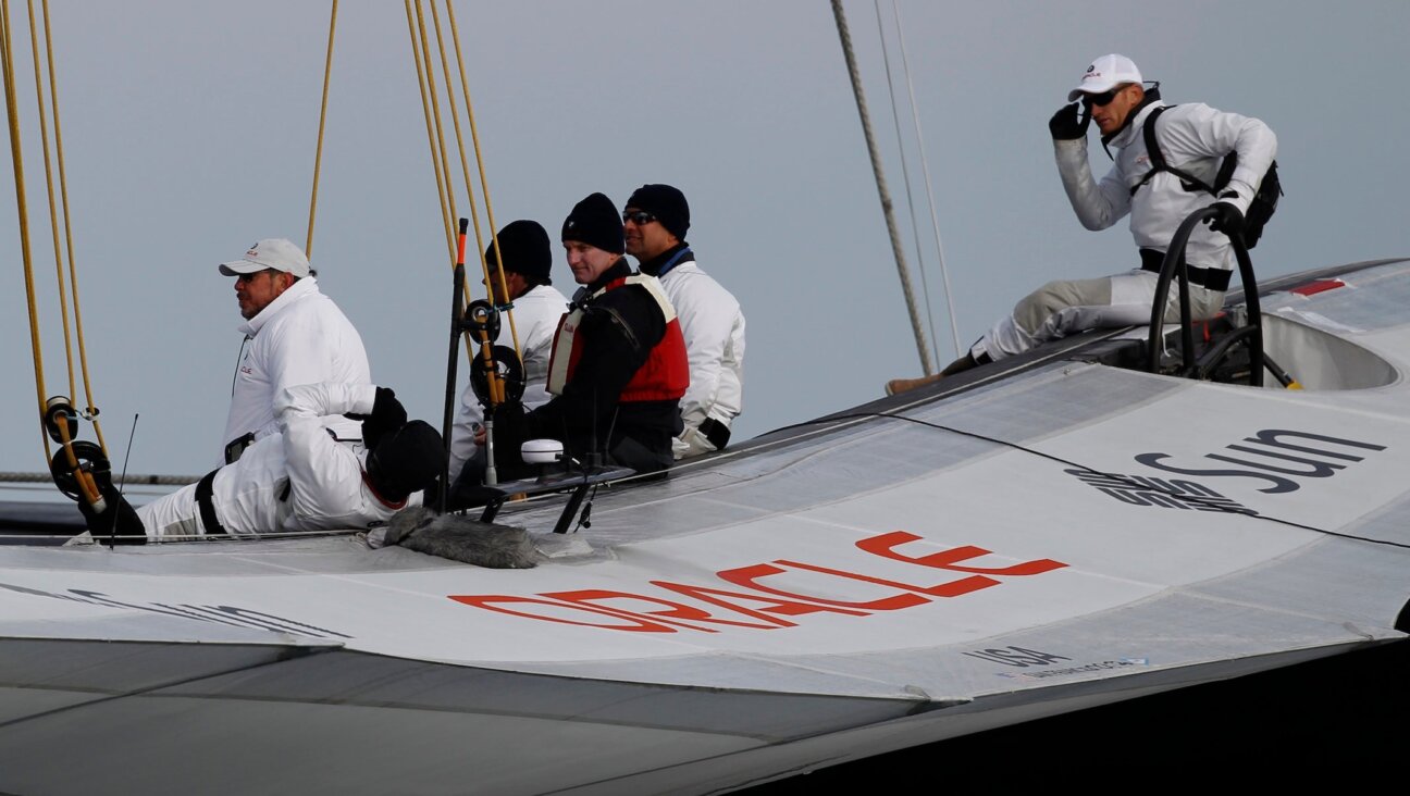Oracle owner Larry Ellison (L) waits on the company’s boat before a race in the America’s Cup on Feb. 14, 2010, off the coast of Spain. 