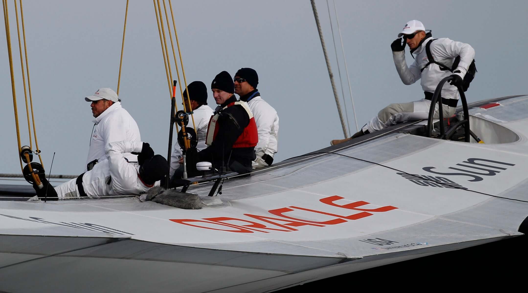 Oracle owner Larry Ellison (L) waits on the company’s boat before a race in the America’s Cup on Feb. 14, 2010, off the coast of Spain. 