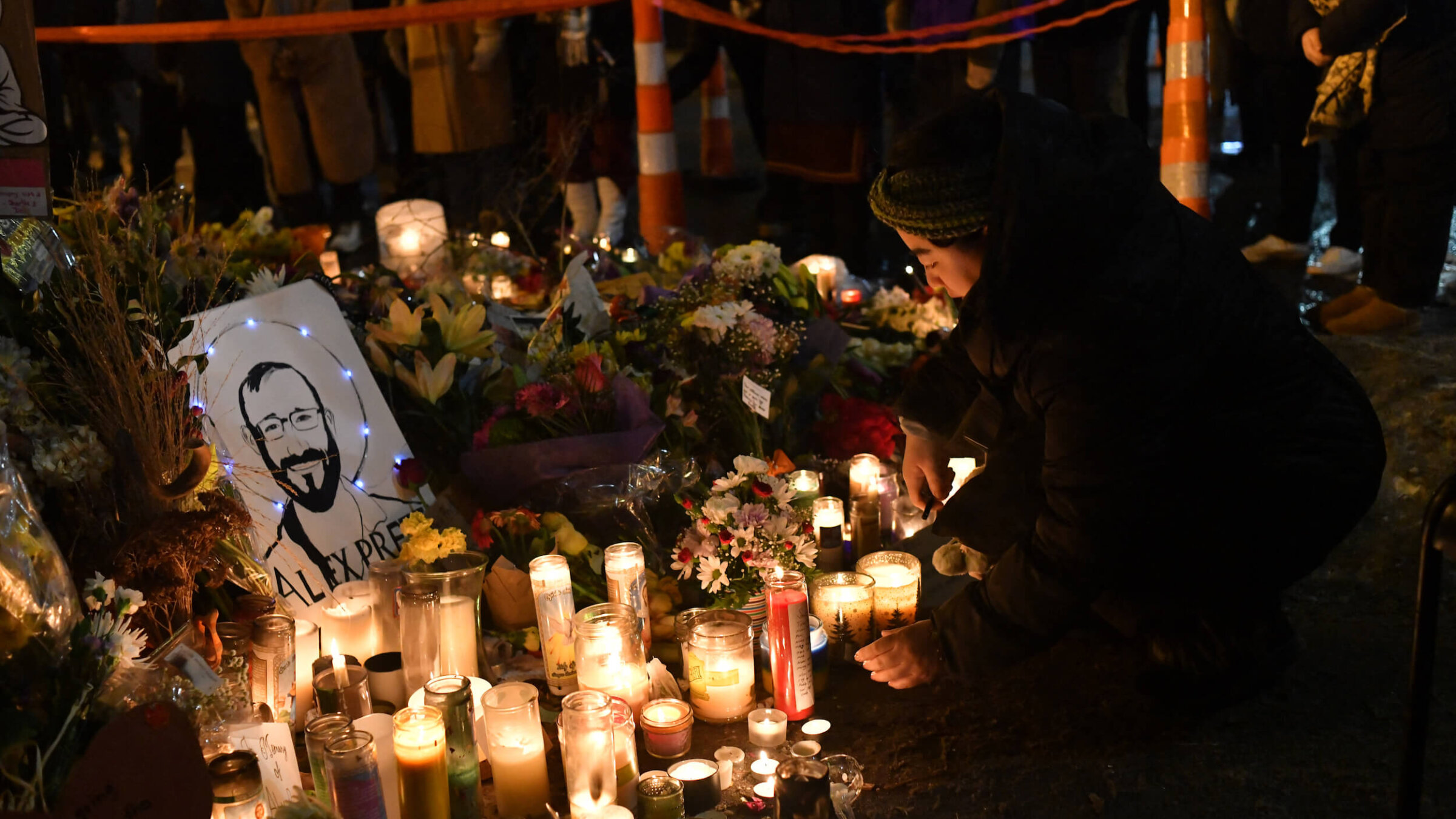 A woman lights a candle on Jan. 26 while mourning at a makeshift memorial in the area where Alex Pretti was shot dead by federal immigration agents in Minneapolis, Minnesota.