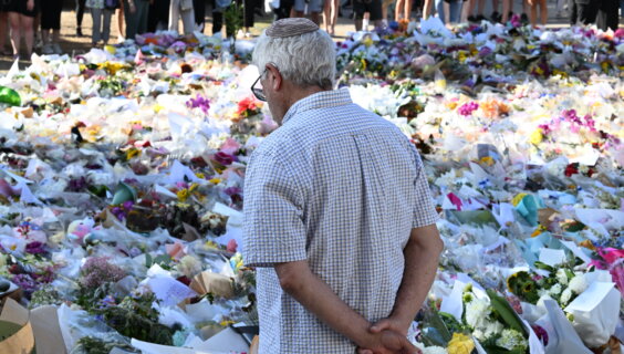 אַ ייִד שטייט בײַם דענקמאָל לעבן דעם באָנדי־ביטש פּאַוויליאָן, דעם 17טן דעצעמבער 2025