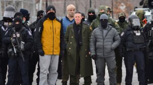 US Customs and Border Protection Commander Gregory Bovino (C) stands flanked by fellow federal agents during a protest against ICE outside the Bishop Whipple Federal Building in Minneapolis, Minnesota, on Jan. 15, 2026.