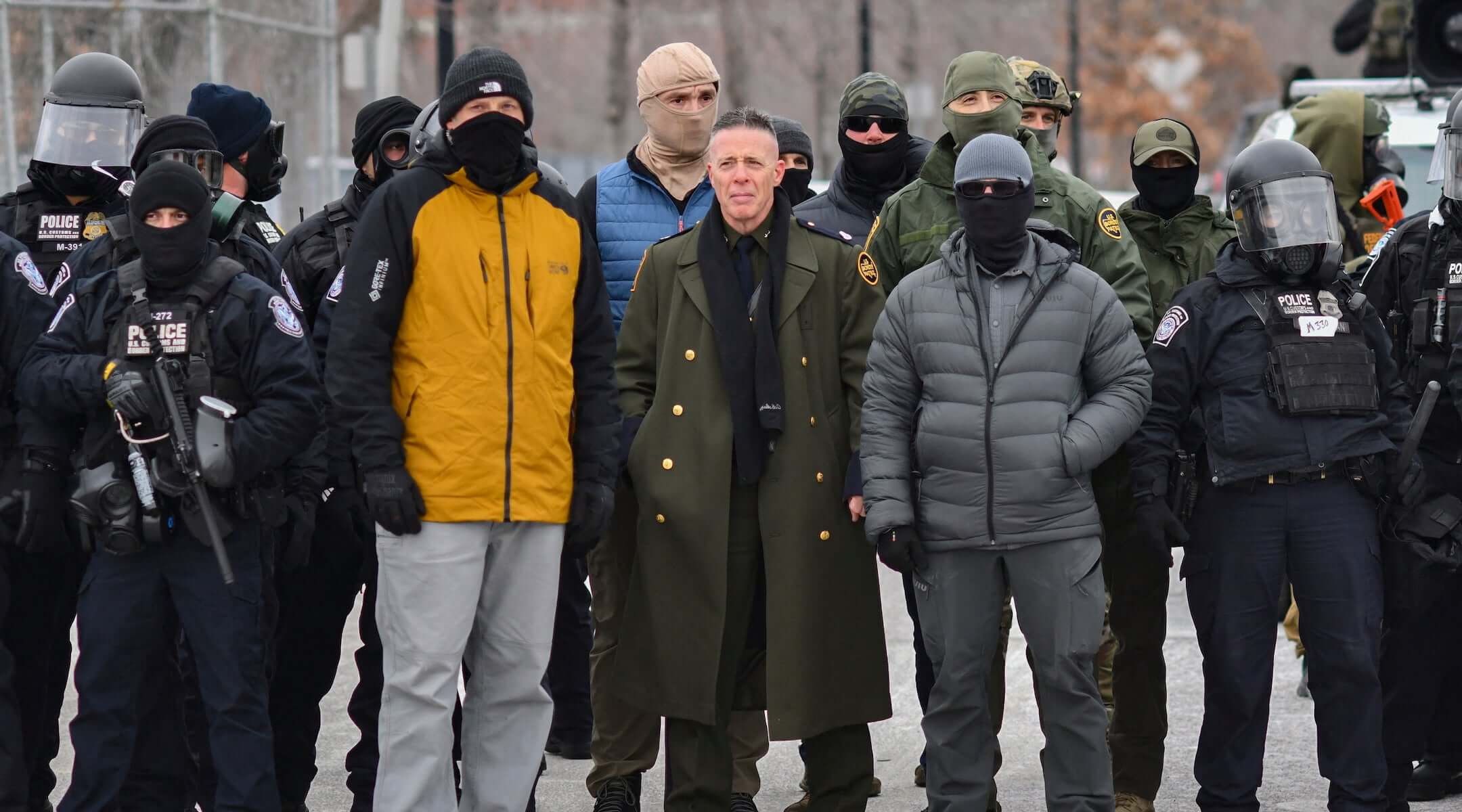 US Customs and Border Protection Commander Gregory Bovino (C) stands flanked by fellow federal agents during a protest against ICE outside the Bishop Whipple Federal Building in Minneapolis, Minnesota, on Jan. 15, 2026.