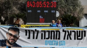 A photograph shows a banner bearing a portrait Ran Gvili, the last hostage held in Gaza, the day after his remains were brought home by Israeli forces, in Hostage Square in Tel Aviv on Jan. 27, 2026.