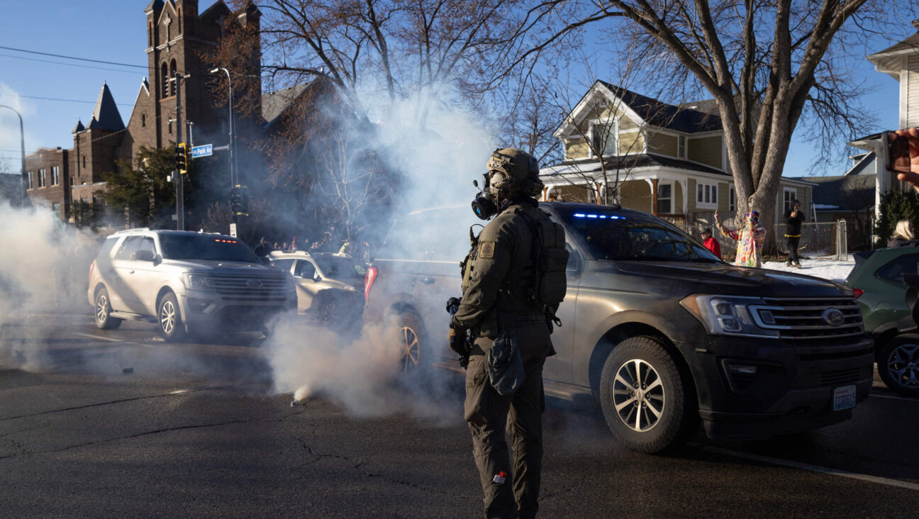 Tear gas tossed by federal immigration agents fills the air as agents clash with residents in Minneapolis, Minnesota on Jan. 13.