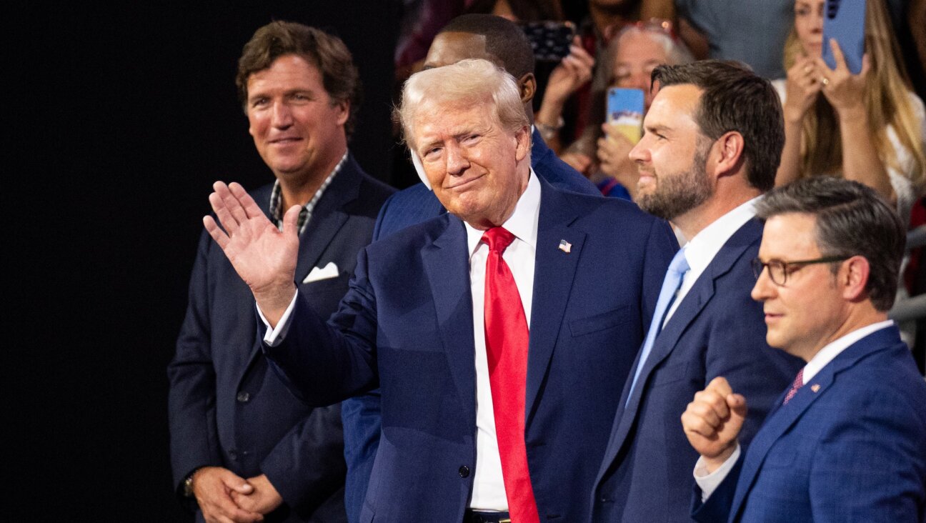 Former President Donald Trump waves to the crowd at the Republican National Convention at the Fiserv Forum in Milwaukee, Wisc., on Monday, July 15, 2024. Trump is flanked from left by Tucker Carlson, Rep. Byron Donalds, R-Fla., Vice-President nominee Sen. J.D. Vance, R-Ohio, and Speaker of the House Mike Johnson, R-La. 