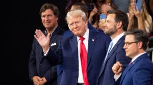 Former President Donald Trump waves to the crowd at the Republican National Convention at the Fiserv Forum in Milwaukee, Wisc., on Monday, July 15, 2024. Trump is flanked from left by Tucker Carlson, Rep. Byron Donalds, R-Fla., Vice-President nominee Sen. J.D. Vance, R-Ohio, and Speaker of the House Mike Johnson, R-La. 