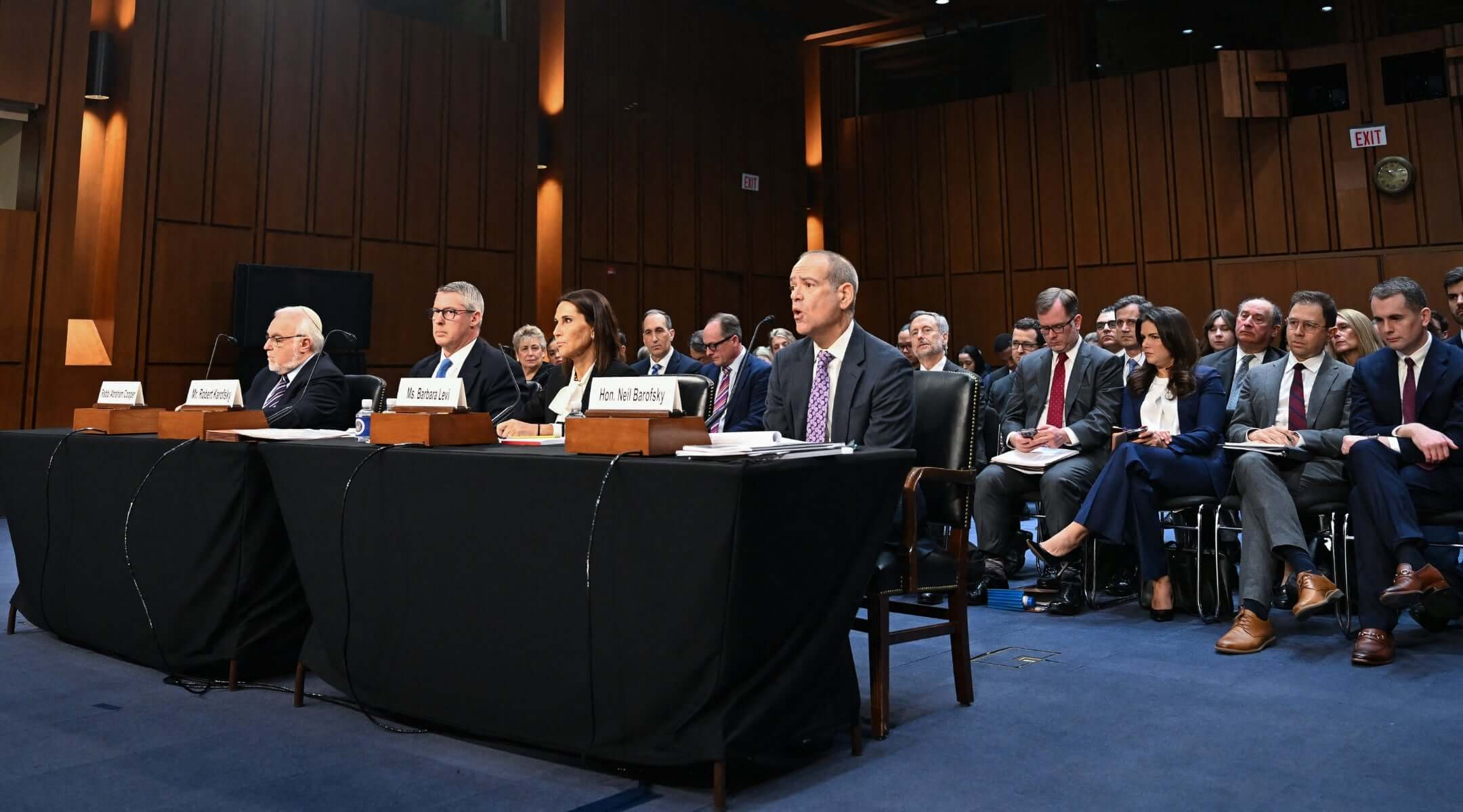From left to right: Rabbi Abraham Cooper, Robert Karofsky, Global Wealth Management President at UBS Americas, Barbara Levi, General Counsel at UBS Group AG, and Neil Barofsky, partner at Jenner and Block LLP, testify during a Senate Judiciary Committee hearing.