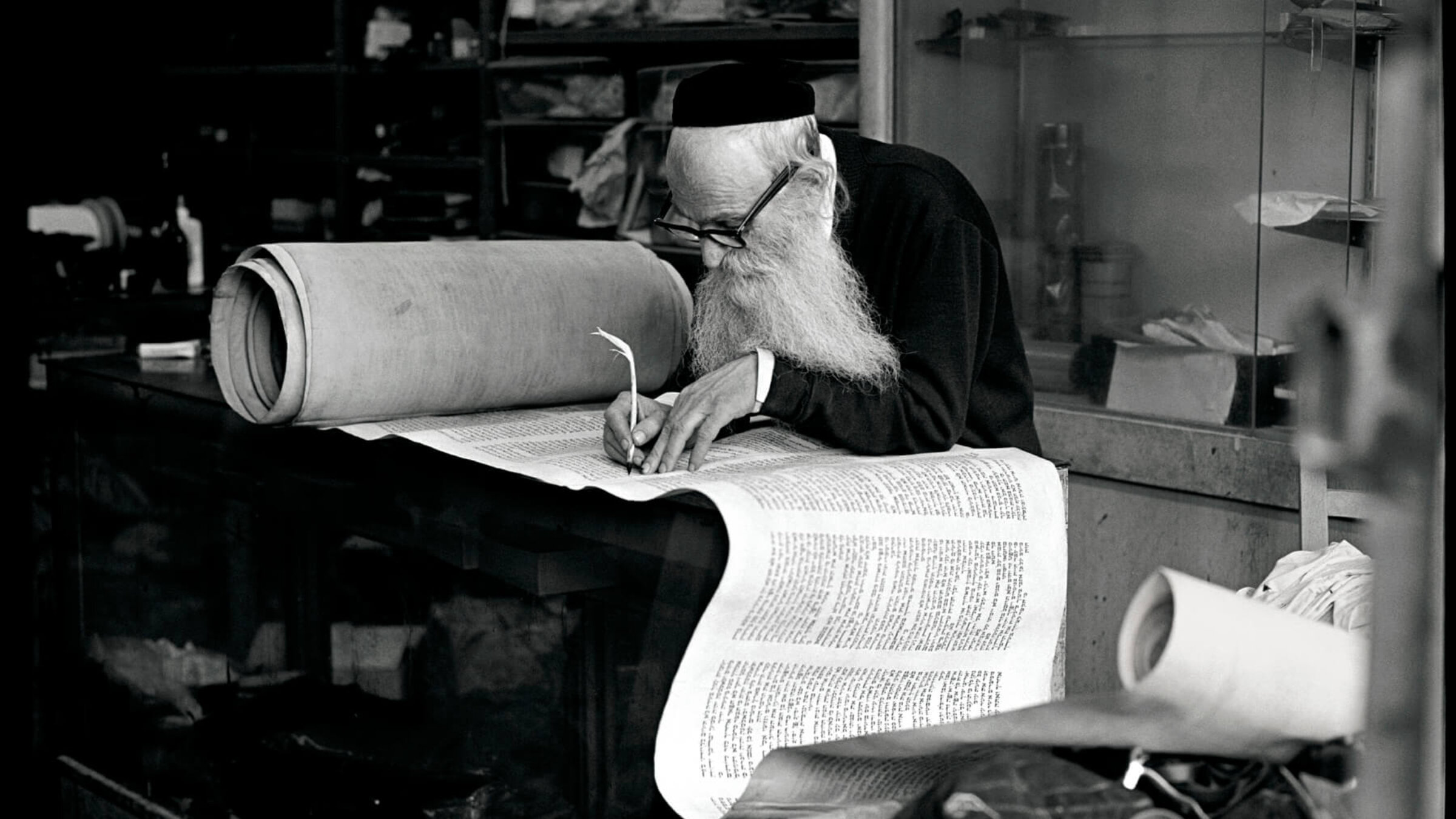 Rabbi Eisenbach, Scribe, Lower East Side, 1975. Aron said the rabbi, who he had been spending time with, had refused to allow his photo to be taken. One day, Aron snapped the photo without asking and, when the rabbi looked over his glasses at the sound of the shutter, ran away. Later, he brought the print to show the scribe, who was delighted by it in the end.