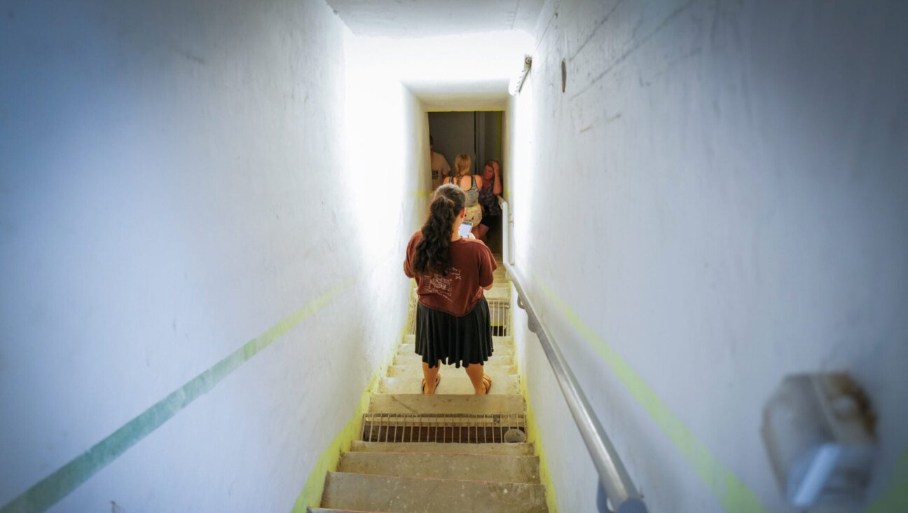 People take cover as siren warns of incoming missiles fired from Iran, at a public bomb shelter in Katzrin, northern Israel, June 19, 2025. 