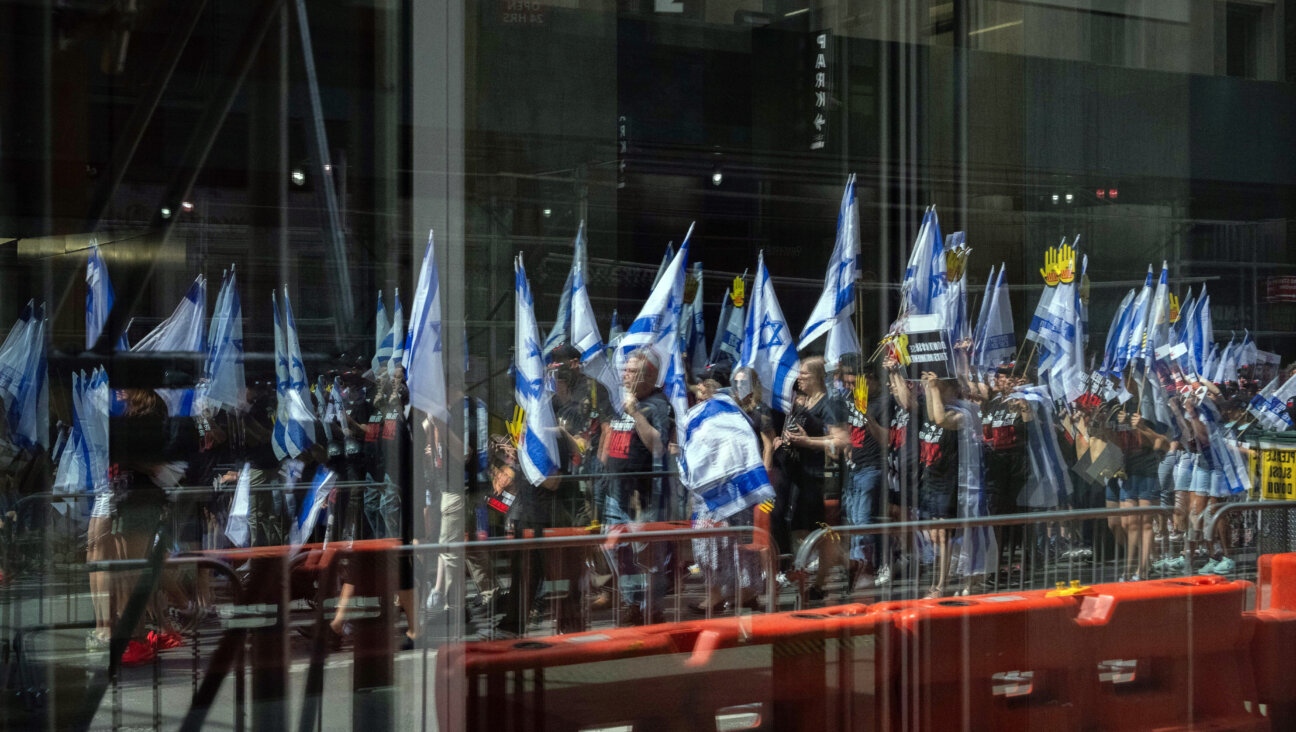 People holding Israel flags are reflected in a window before the Israel Day on Fifth parade on June 2, 2024 in New York City.