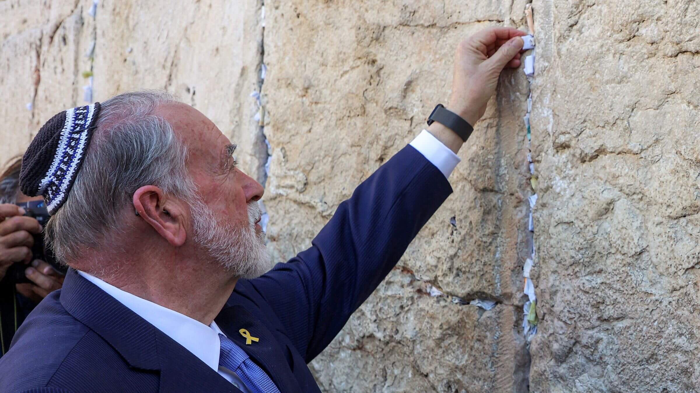 The US' ambassador to Israel Mike Huckabee places a note given to him from US President Donald Trump in the cracks of the Western Wall, the holiest site where Jews are allowed to pray, during Huckabee's visit to the holy site in the old city of Jerusalem on April 18, 2025.