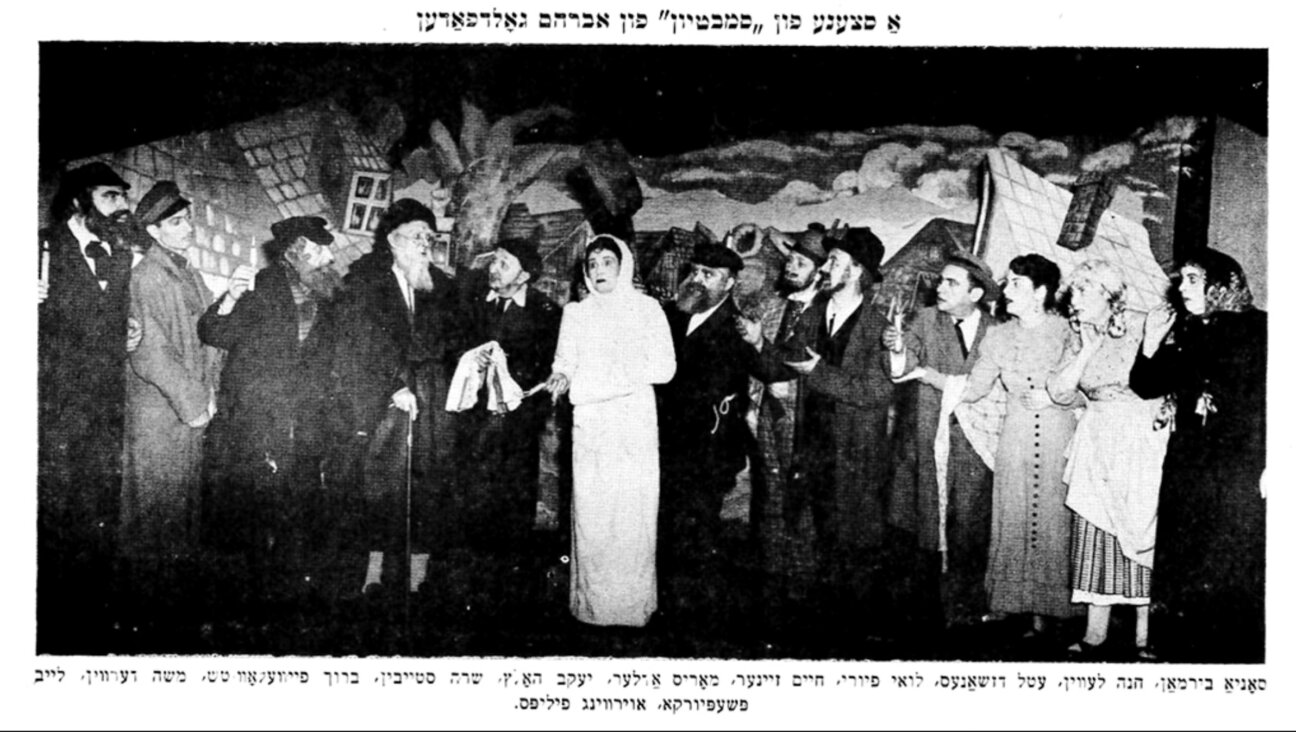 אַ צײַטונג־אויסשניט פֿון אַ סצענע אין גאָלדפֿאַדנס פּיעסע „סמבטיון“, דאַטע אומבאַקאַנט