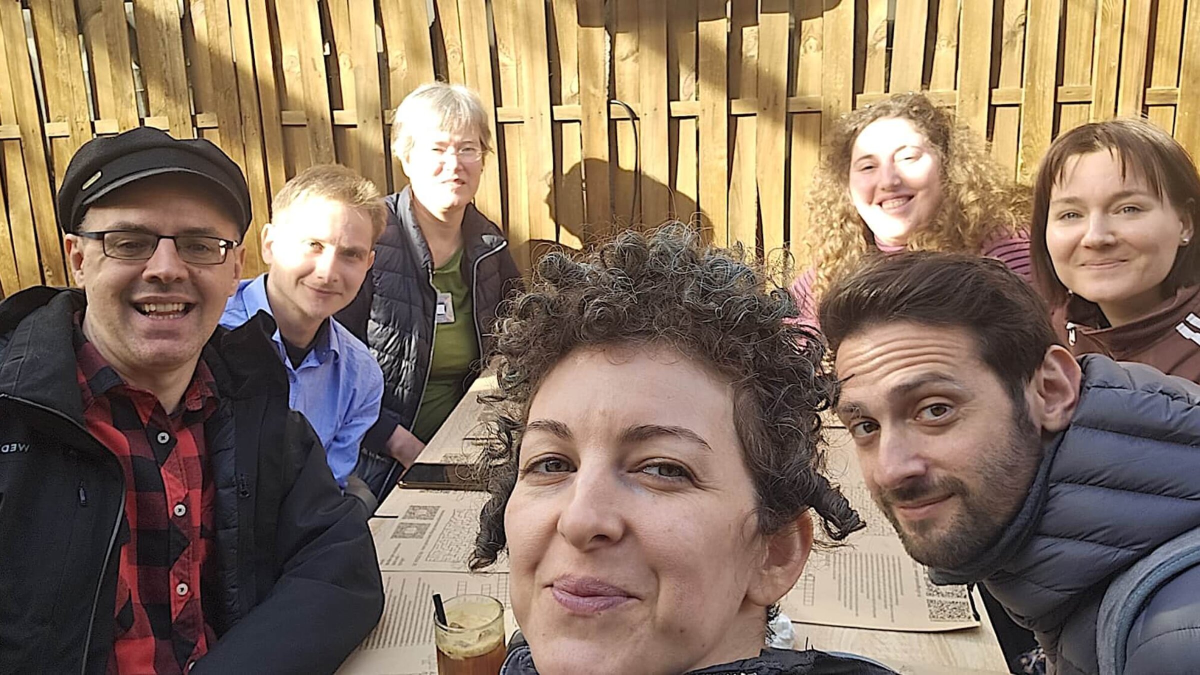 אַ גרופּע באַטייליקטע אין דער פּראָגראַם וואַרטן אויף אַ רומענישער מאָלצײַט אין אַן אָרטיקן רעסטאָראַן