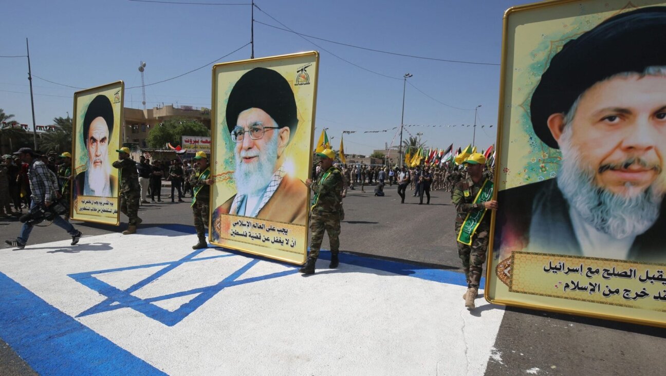 Portraits of Iran's Supreme Leader Ali Khamenei (center), his predecessor and Islamic Revolution founder Ayatollah Ruhollah (left) and late Iraqi Shiite cleric Mohammed Baqer al-Sadr with a slogan reading in Arabic : “He who accepts peace with Israel, is no more a Muslim,” are pictured during a military parade marking Al-Quds (Jerusalem) International Day in Baghdad, on May 31, 2019.