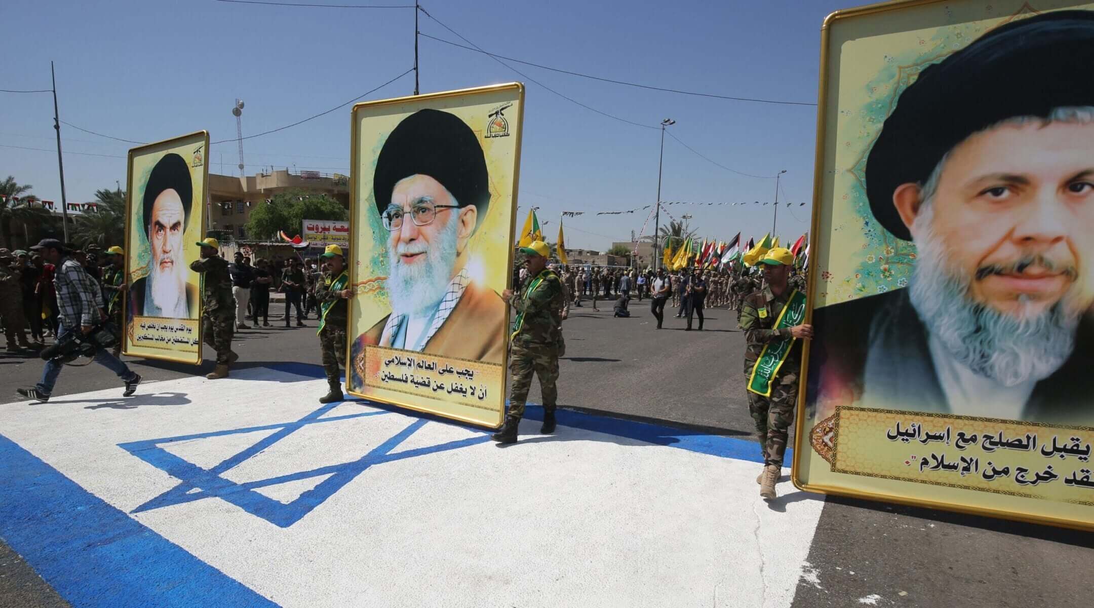 Portraits of Iran's Supreme Leader Ali Khamenei (center), his predecessor and Islamic Revolution founder Ayatollah Ruhollah (left) and late Iraqi Shiite cleric Mohammed Baqer al-Sadr with a slogan reading in Arabic : “He who accepts peace with Israel, is no more a Muslim,” are pictured during a military parade marking Al-Quds (Jerusalem) International Day in Baghdad, on May 31, 2019.