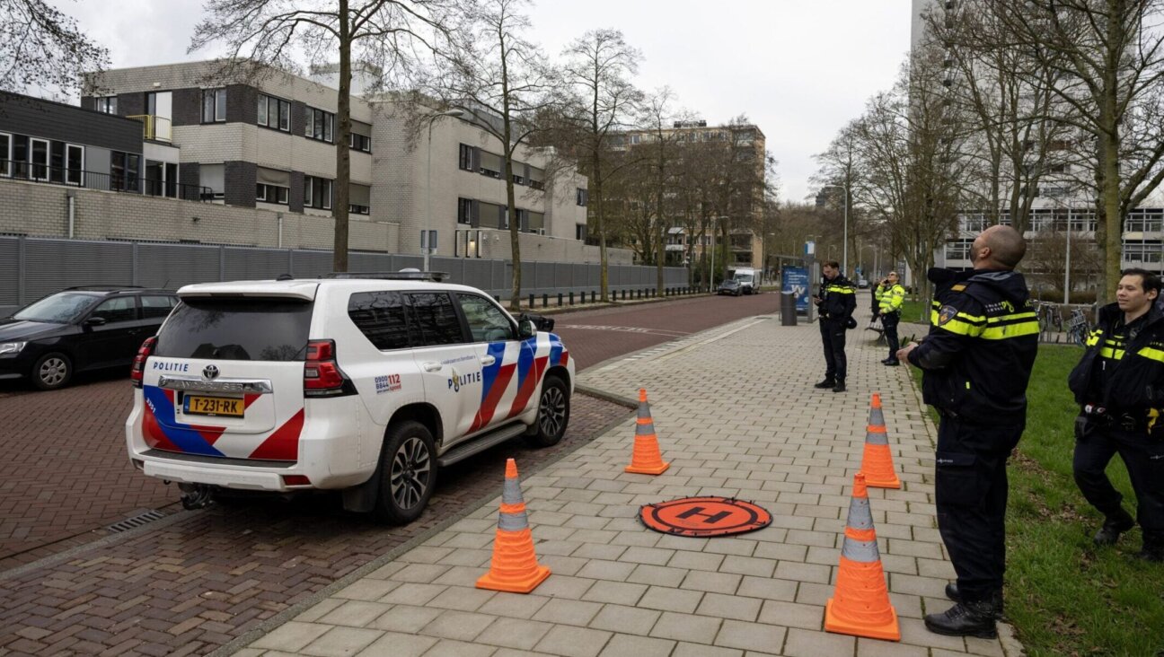 Police officers stand outside a Jewish school where an explosion was reported overnight in Amsterdam on March 14, 2026.