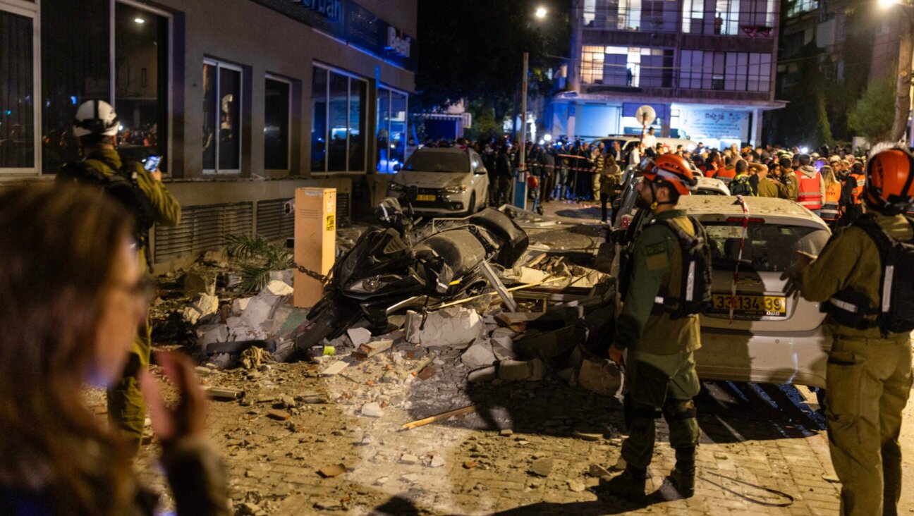 First responders work at the site of a building hit by an Iranian missile strike in Ramat Gan, on the outskirts of Tel Aviv, early on March 18, 2026.