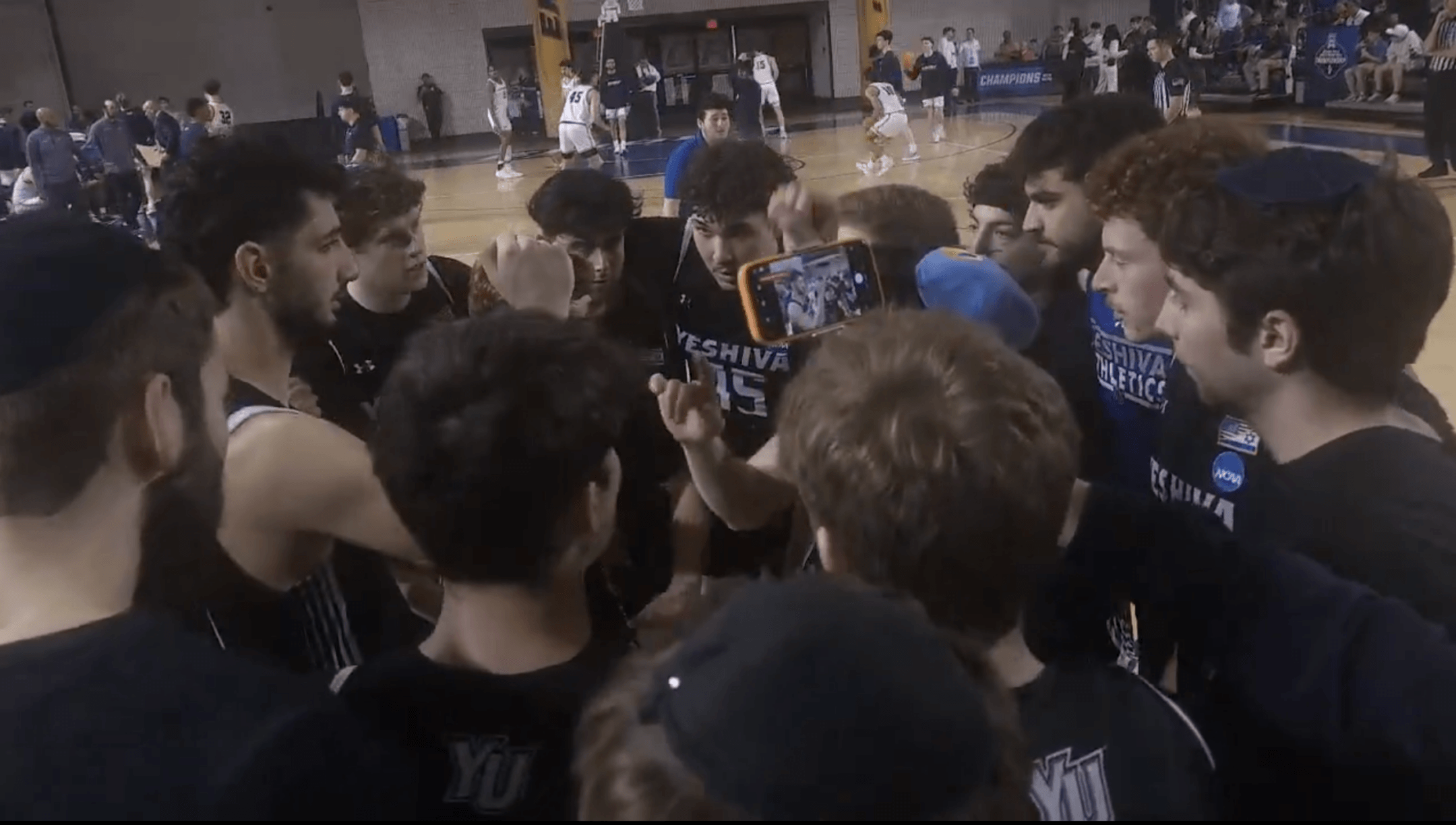 Members of the Yeshiva University Maccabees huddle during their Sweet 16 game against Emory University, March 13, 2026, in Atlanta.