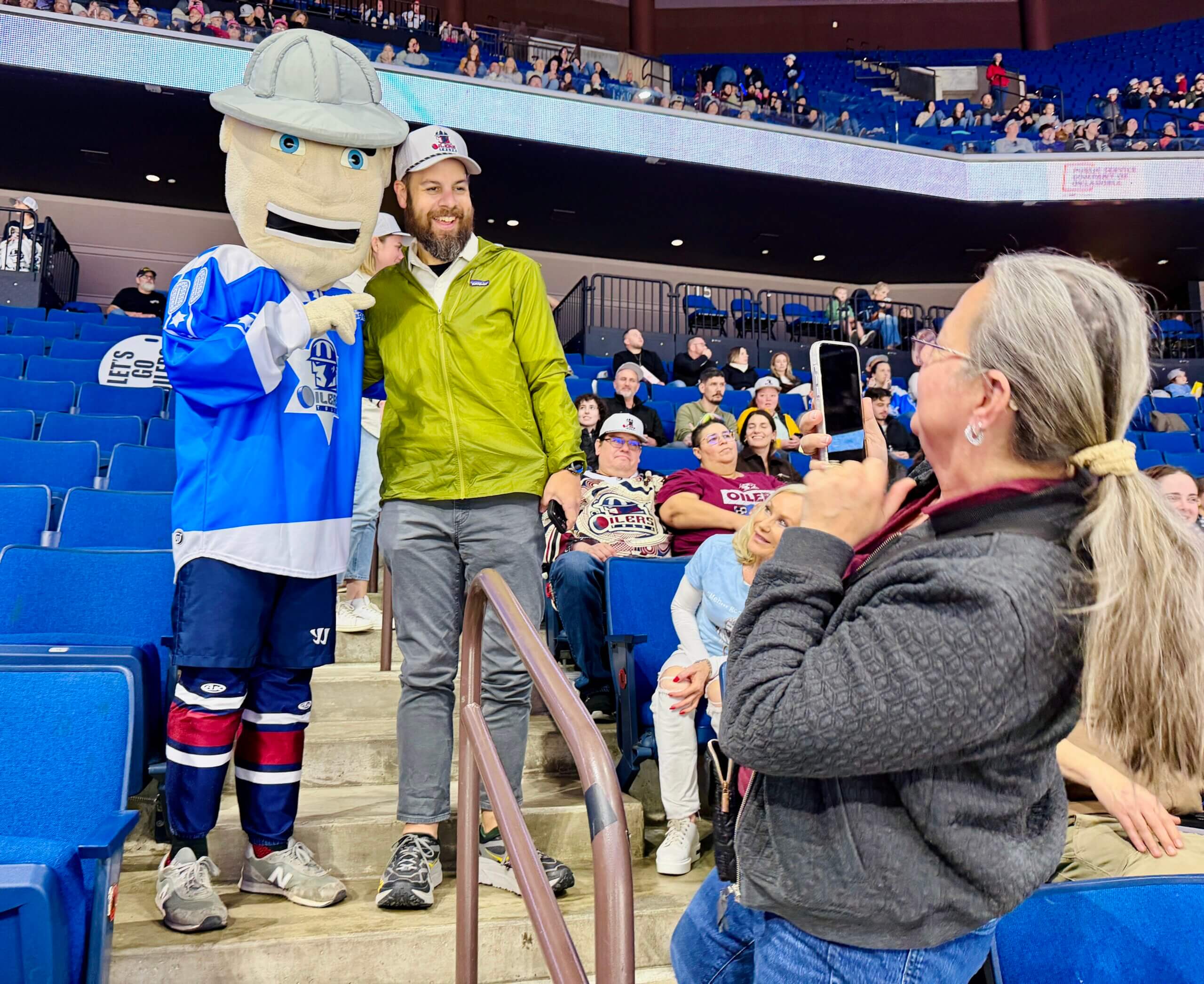 Rabbi Daniel Kaiman poses at a hockey game with the Tulsa Oilers mascot. The mascot is wearing a special jersey in honor of Jewish Heritage Night.