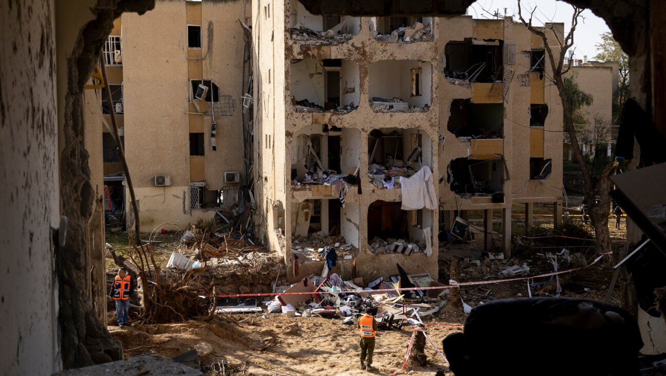 An emergency responder stands near destroyed buildings after an Iranian missile strike on March 22, 2026 in Arad, Israel.
