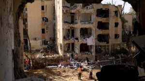 An emergency responder stands near destroyed buildings after an Iranian missile strike on March 22, 2026 in Arad, Israel.