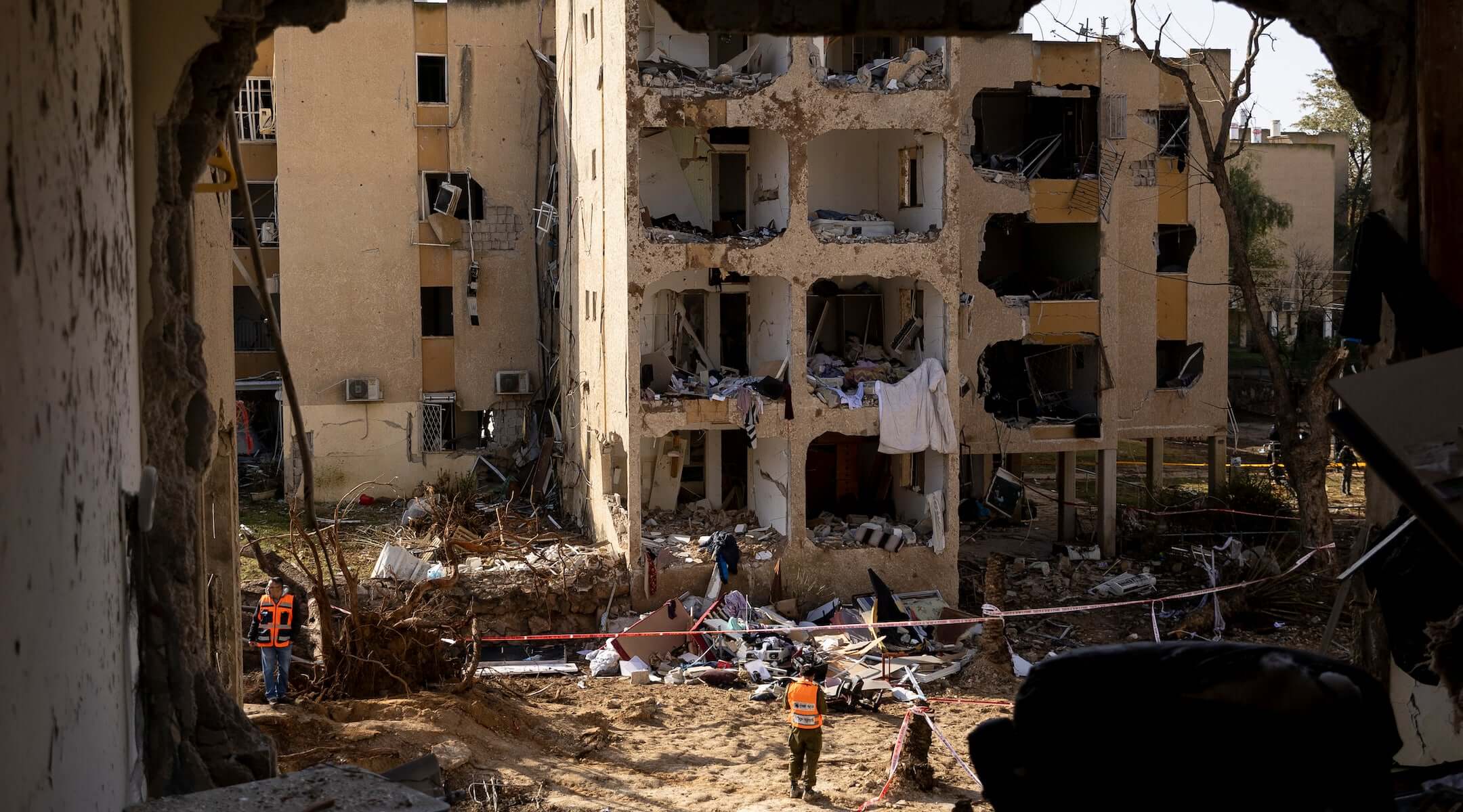 An emergency responder stands near destroyed buildings after an Iranian missile strike on March 22, 2026 in Arad, Israel.