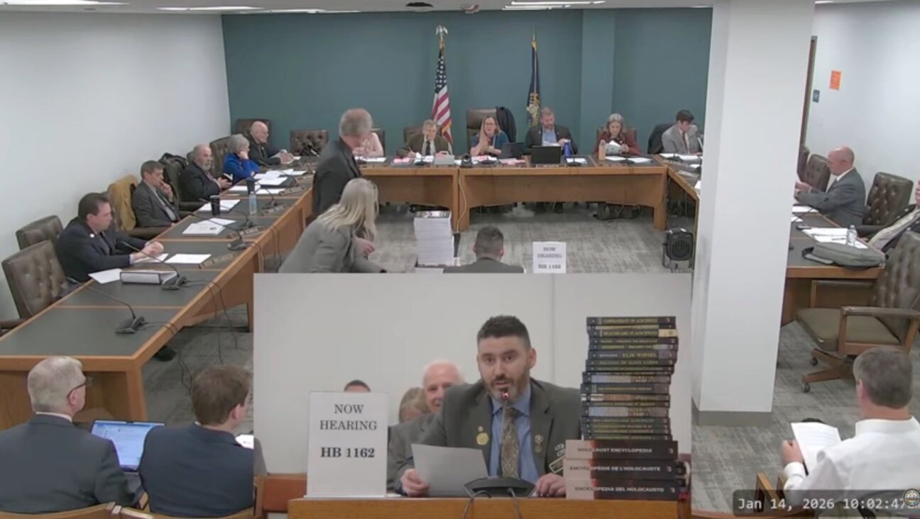 New Hampshire GOP state Rep. Matt Sabourin dit Choinière (center) testifies before a state committee on his proposed amendment to add a Holocaust denier to the state’s Holocaust education commission, Jan. 14, 2026. He is flanked by a stack of Holocaust-denial books. (Screenshot)