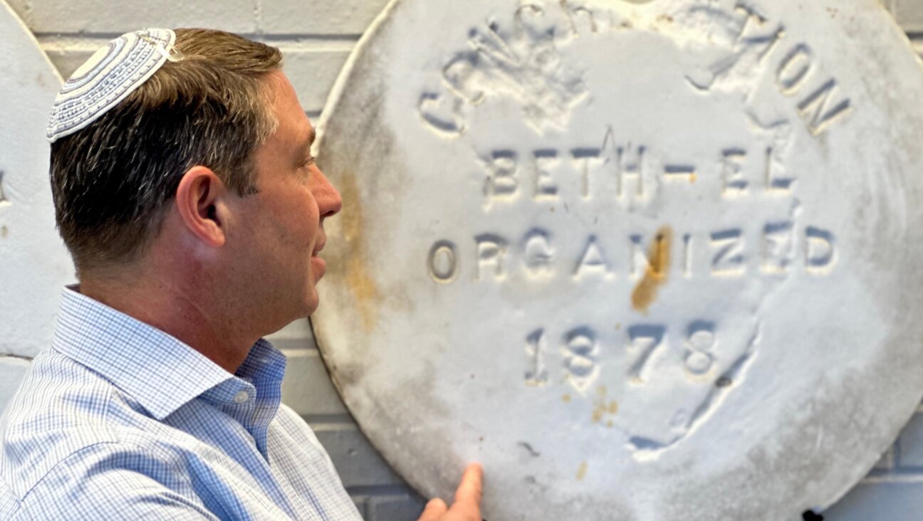 Rabbi Joel Fleekop points to a monument marking the 1878 consecration of Temple Beth El in Pensacola, Florida. (Larry Luxner)