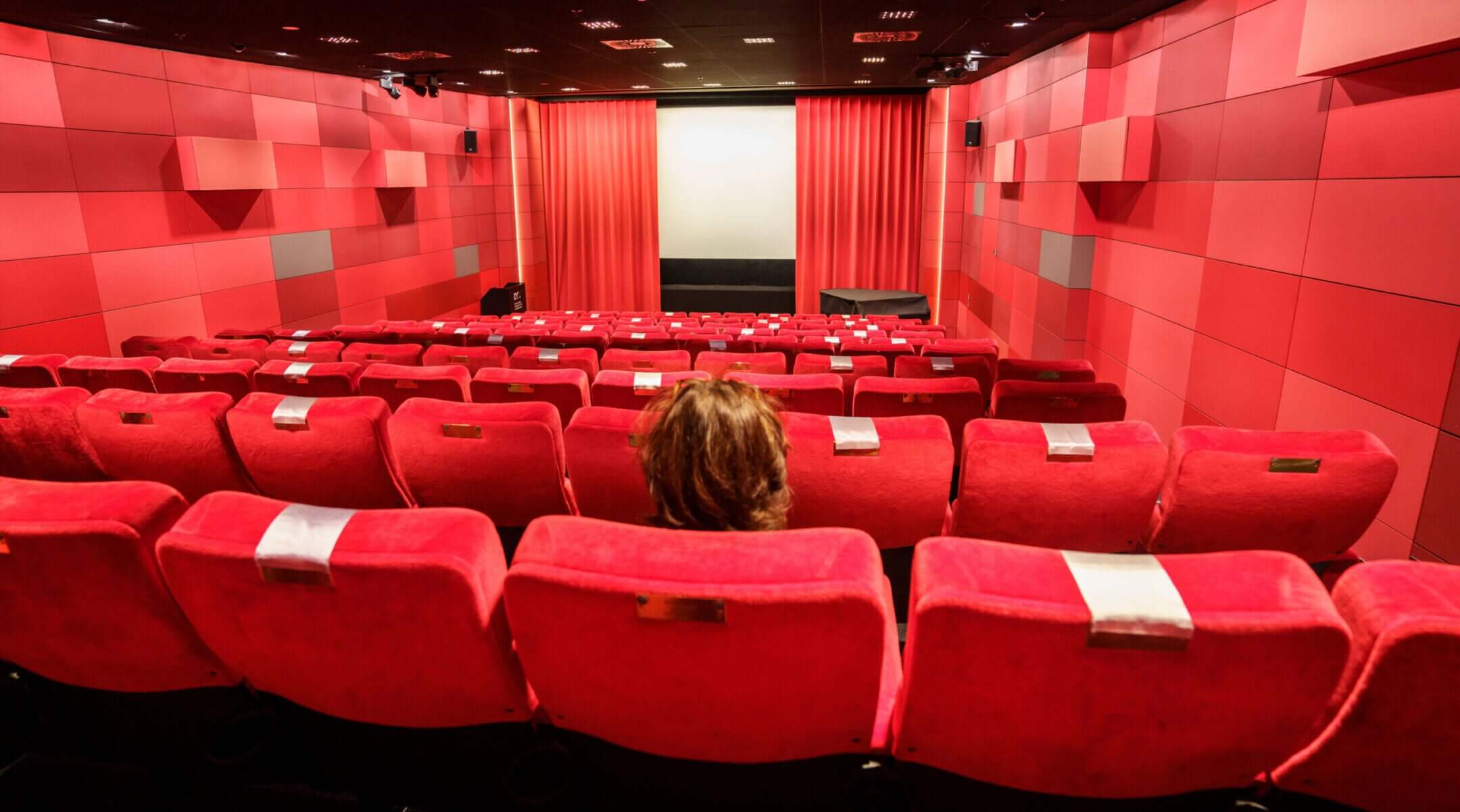 A woman sits alone in a Frankfurt, Germany, cinema in November 2021. (Frank Rumpenhorst/picture alliance via Getty Images)
